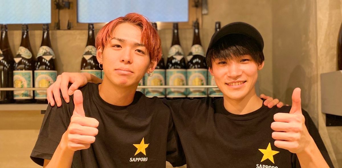 サムズアップするスタッフ2人