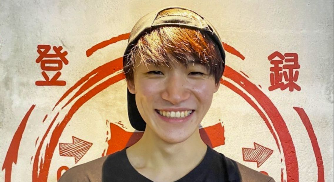 店内の55のロゴの前で笑うスタッフ